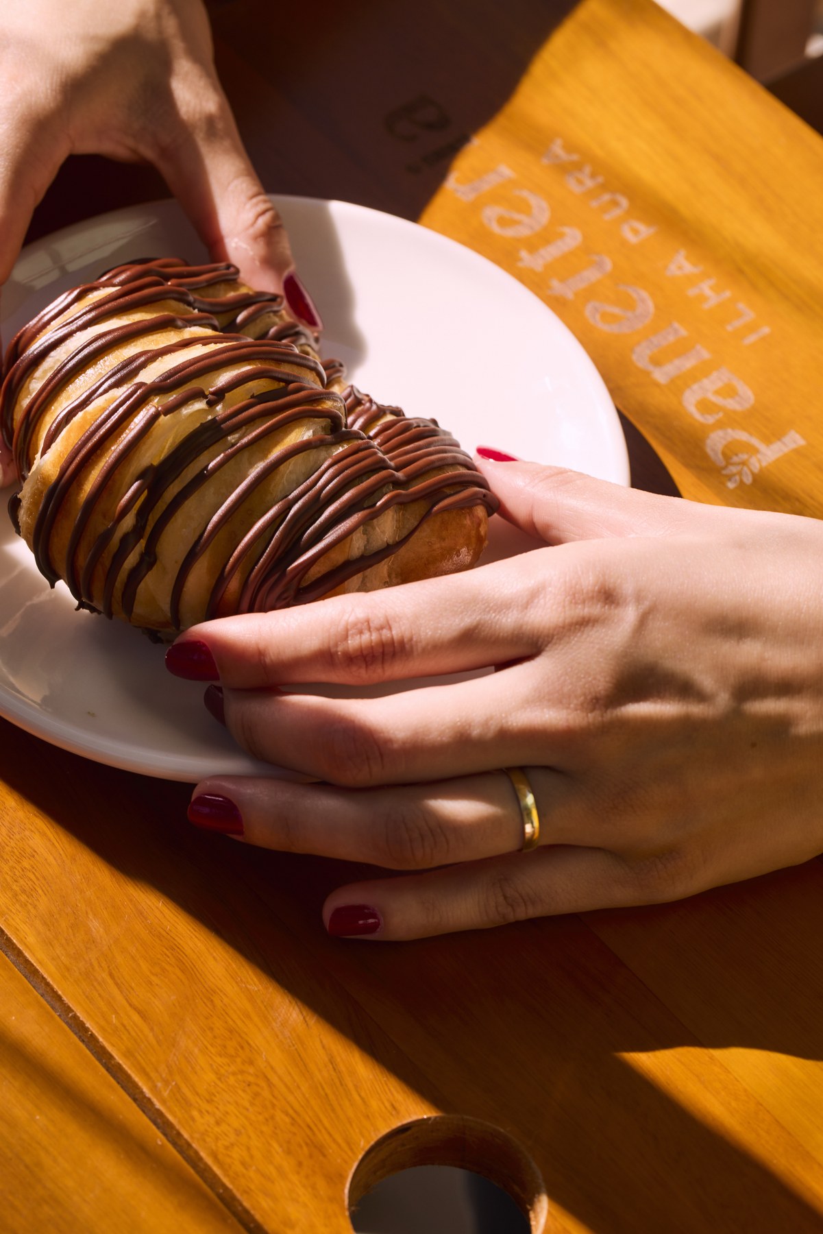 Cliente saboreando um croissant da Panetteria